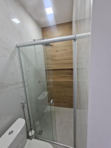 a bathroom with a glass shower with a toilet at Açaí Hostel in Belém