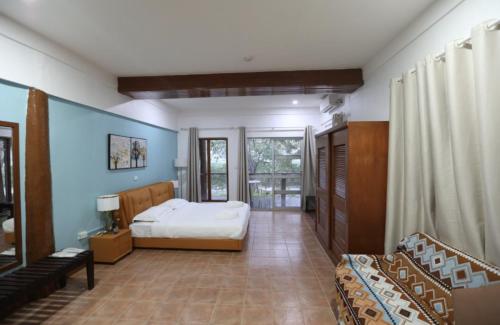 a bedroom with a bed and a couch in it at Rainbow Accommodations in Nadi