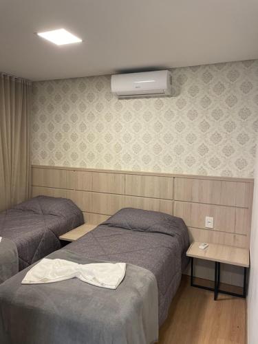 a hotel room with two beds and a heater at Apartamento Bolognese in Canela