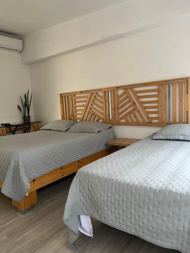 two beds sitting next to each other in a bedroom at Hotel 42 Avenida in Palmira
