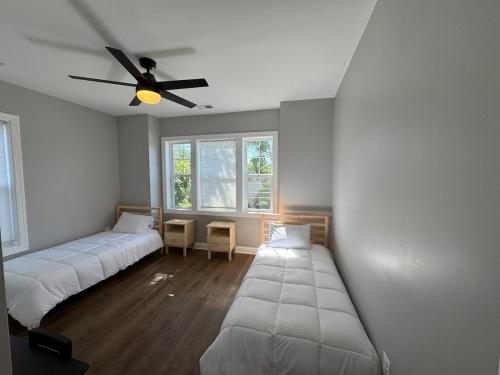 a room with two beds and a ceiling fan at Modern 4BR Family Home with Grill in Silver Spring