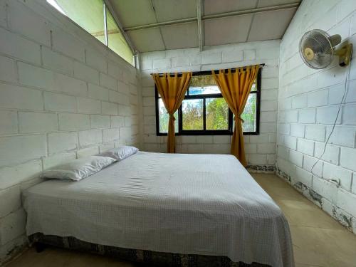 ein Schlafzimmer mit einem großen Bett in einer Ziegelwand in der Unterkunft Cabaña Flor Hermosa in Santo Domingo de los Colorados