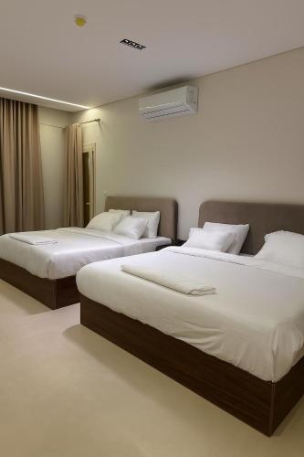 two beds in a hotel room with white sheets at Imperial Luxury Hotel in Cairo