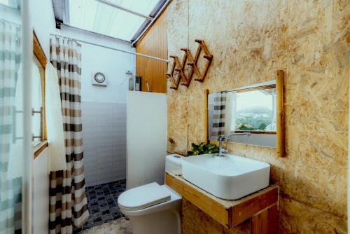 a bathroom with a sink and a toilet and a mirror at บ้านแสงจันทร์2 แอร์ ม่อนแจ่ม วิวดอยหลวงเชียงดาว in Mon Jam
