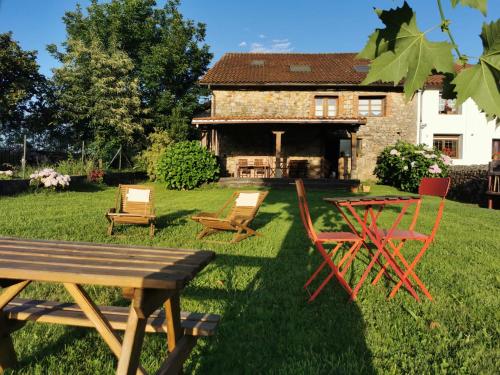 a picnic table and chairs in front of a house at El Espesedo, casa rural a 5km del Parque de Cabárceno in Argomilla