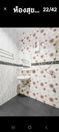 a bathroom with a sink and flowers on the wall at Teahouse in Ban Suan