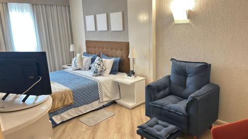 a bedroom with a bed and a chair and a desk at GRU Airport Hotel - STAY HERE in Guarulhos