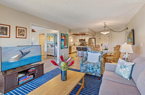 a living room with a couch and a tv at Maui Banyan 1 bedroom, ocean view, steps to beach, king-size bed, full kitchen in Wailea