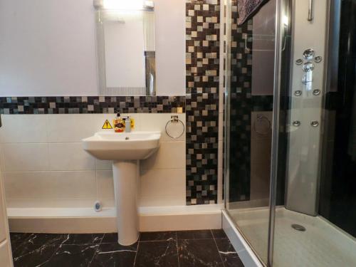 a bathroom with a sink and a shower at Mayfield Cottage in Blackpool