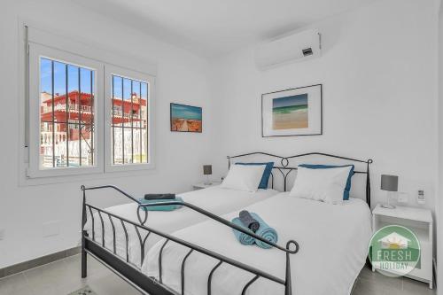 ein Schlafzimmer mit einem Bett und zwei Fenstern in der Unterkunft Family cottage in Benajarafe w pool and sea view in Vélez-Málaga