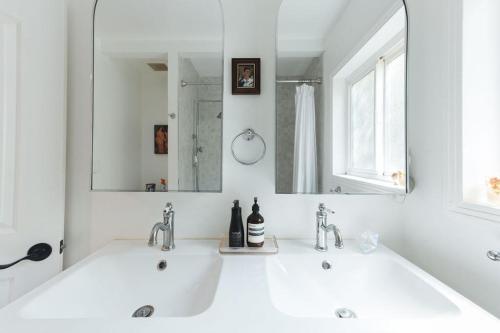 ein weißes Badezimmer mit zwei Waschbecken und einem Spiegel in der Unterkunft Lovely 2 Bedroom 1 Bathroom Home in Prime Burbank Location in Burbank