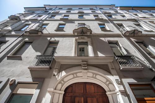 a tall white building with a wooden door at Pretty twin Palatina Centro Torino in Turin