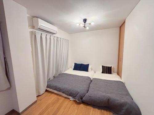 a small bedroom with a bed and a window at アンファング森ノ宮 in Osaka