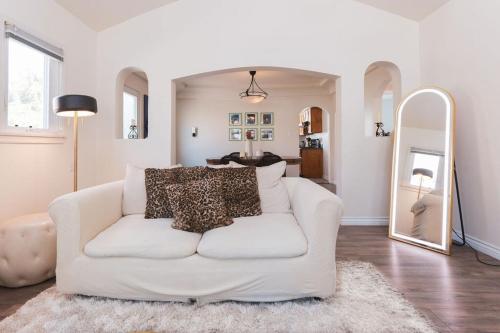 ein Wohnzimmer mit einem weißen Sofa und einem Spiegel in der Unterkunft Lovely 2 Bedroom 1 Bathroom Home in Prime Burbank Location in Burbank