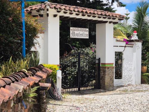 a gate to a house with a sign on it at AEROPUERTO-Rionegro- MONTEOLIVO COLONIAL in Rionegro