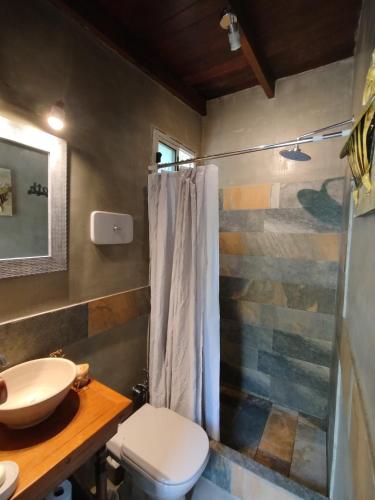 a bathroom with a toilet and a sink and a shower at Tekora con piscina Climatizada in Balneario Argentino