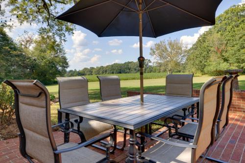 a wooden table with chairs and an umbrella at 3 Mi to Dtwn Greer Mountain-View Home! in Greer