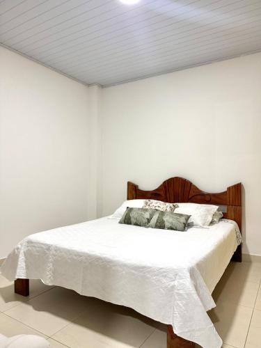 a bedroom with a bed with white sheets and pillows at Acogedor apartamento in Leticia