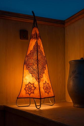 a lamp sitting on a table next to a vase at Auberge la belle vue dades in Akhendachou nʼAït Ouffi