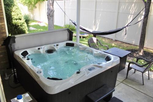 サンディにあるCherry Hill Retreat w Hot Tub and Close to SLCの裏庭のジャクジータブ(椅子付)
