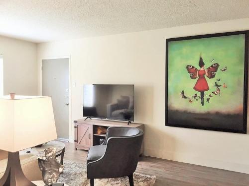 a living room with a chair and a painting on the wall at Perfect Perk Marquee Uptown Unit 121 Galleria 2br 2ba in Houston