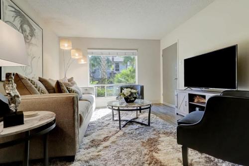 a living room with a couch and a tv at Perfect Perk Marquee Uptown Unit 121 Galleria 2br 2ba in Houston