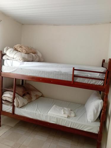 two bunk beds in a small room with towels at Casa térreo in São José dos Pinhais