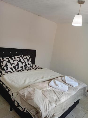 Una cama con dos toallas en una habitación en Casa térreo, en São José dos Pinhais