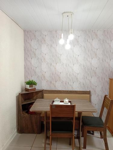 Un comedor con mesa y sillas de madera. en Casa térreo, en São José dos Pinhais