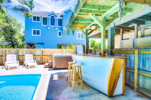a patio with a bar and a swimming pool at 1600 - 5 O`clock Somewhere in Corolla