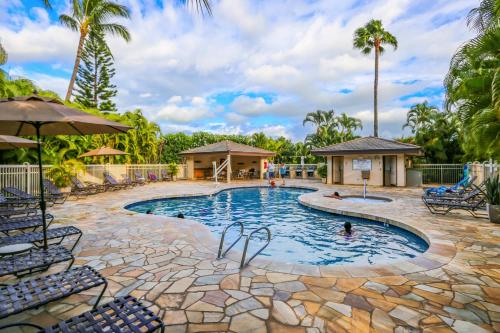 a pool at a resort with palm trees at Maui Banyan 1 bedroom, ocean view, steps to beach, king-size bed, full kitchen in Wailea