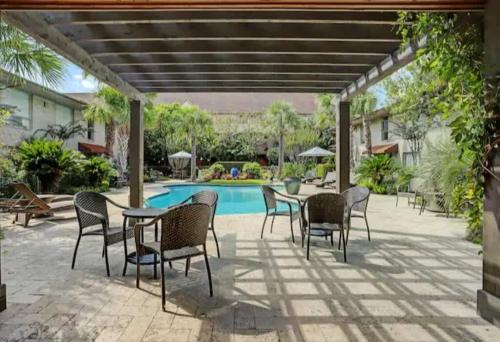 a patio with a table and chairs and a pool at Spring Deals Walk to Galleria Holiday Ready Unit 108 in Houston