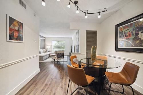 a dining room with a glass table and chairs at Spring Deals Walk to Galleria Holiday Ready Unit 108 in Houston