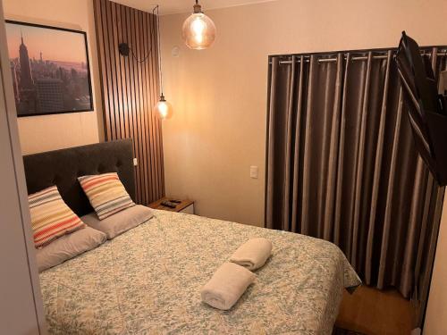 ein Schlafzimmer mit einem Bett und einem Handtuch darauf in der Unterkunft Tempo Moderno Departamento in San Antonio