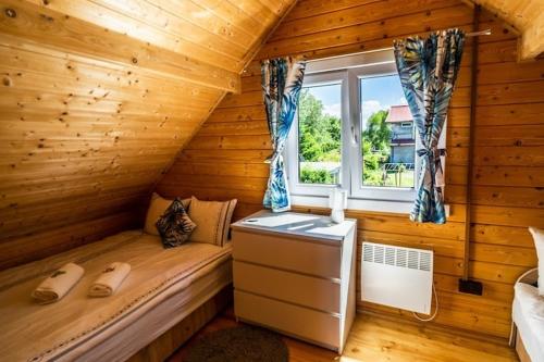 una baita di tronchi con letto e finestra di Comfortable holiday homes with a pool a Ustronie Morskie