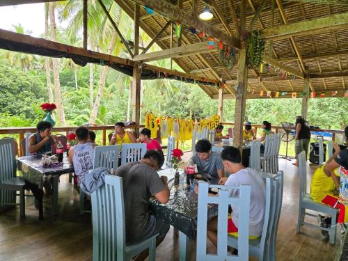 a group of people sitting at tables in a restaurant at International Cruisers Seafront Beach Resort and Farm in San Agustin