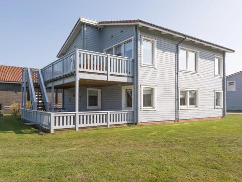 a large house with a balcony and a yard at Broad Reach - 28121 in Fritton Norfolk