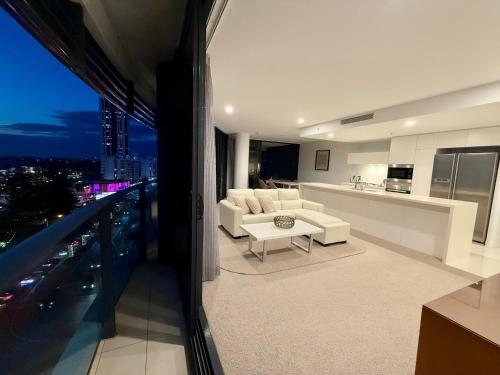 a living room with a white couch and a kitchen at Stunning 2 bed 2 bath 8th floor - GC Getaways in Gold Coast