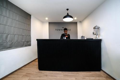 グルガオンにあるHotel O Eliteの部屋の黒いカウンターの後ろに立つ男