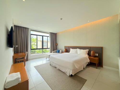 a hotel room with two beds and a large window at Villa Private Pool in Cam Lâm