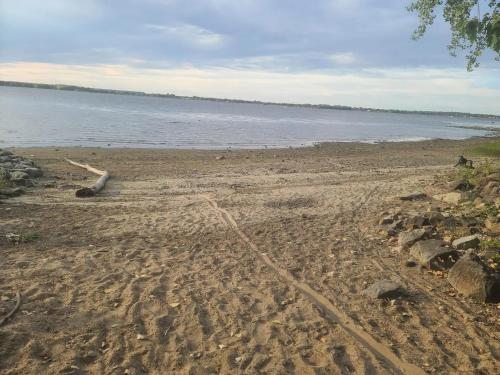 a sandy beach with a body of water at Lakefront Chalet in Montreal in Montréal