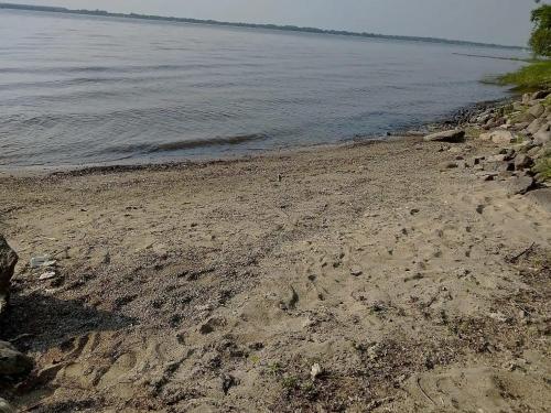 a beach with footprints in the sand and water at Lakefront Chalet in Montreal in Montréal