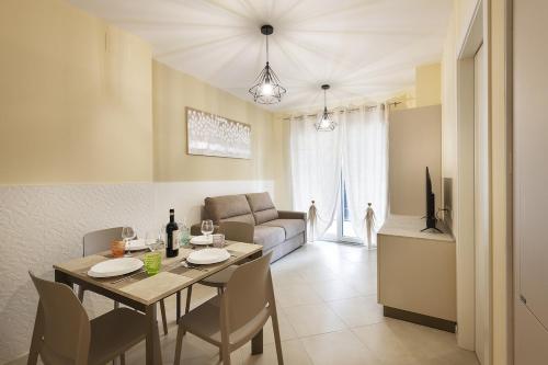 a dining room and living room with a table and chairs at Merlata Suite - 8 min from M1 - private parking in Pero