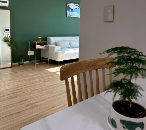 a living room with a couch and a table with a plant at YEOSU Night Sea, Hotel Bedding in Wagol