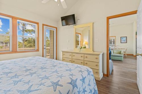 a bedroom with a bed and a dresser and a mirror at 1600 - 5 O`clock Somewhere in Corolla