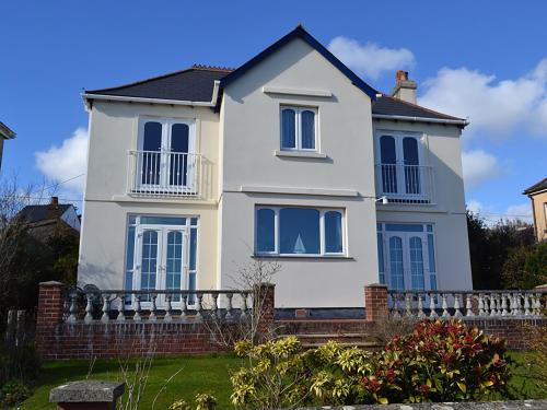 a white house with blue windows and a fence at Riverview in Fowey