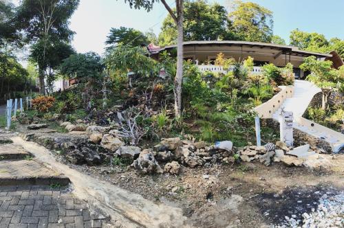 a garden with a staircase in front of a house at Pondok Indah Teluk Asmara in Roworante