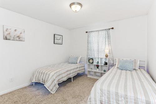 a bedroom with two beds and a window at Warm and Inviting 4BR Home, Perfect for Families in Pensacola