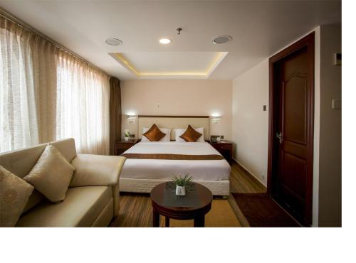 a hotel room with a bed and a couch at KGA Elite Continental Hotel in Thiruvalla