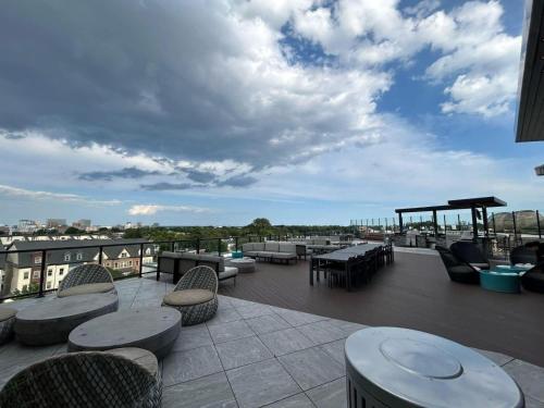 Un patio con mesas y sillas en un tejado. en Altura Apartment Arlington, en Arlington